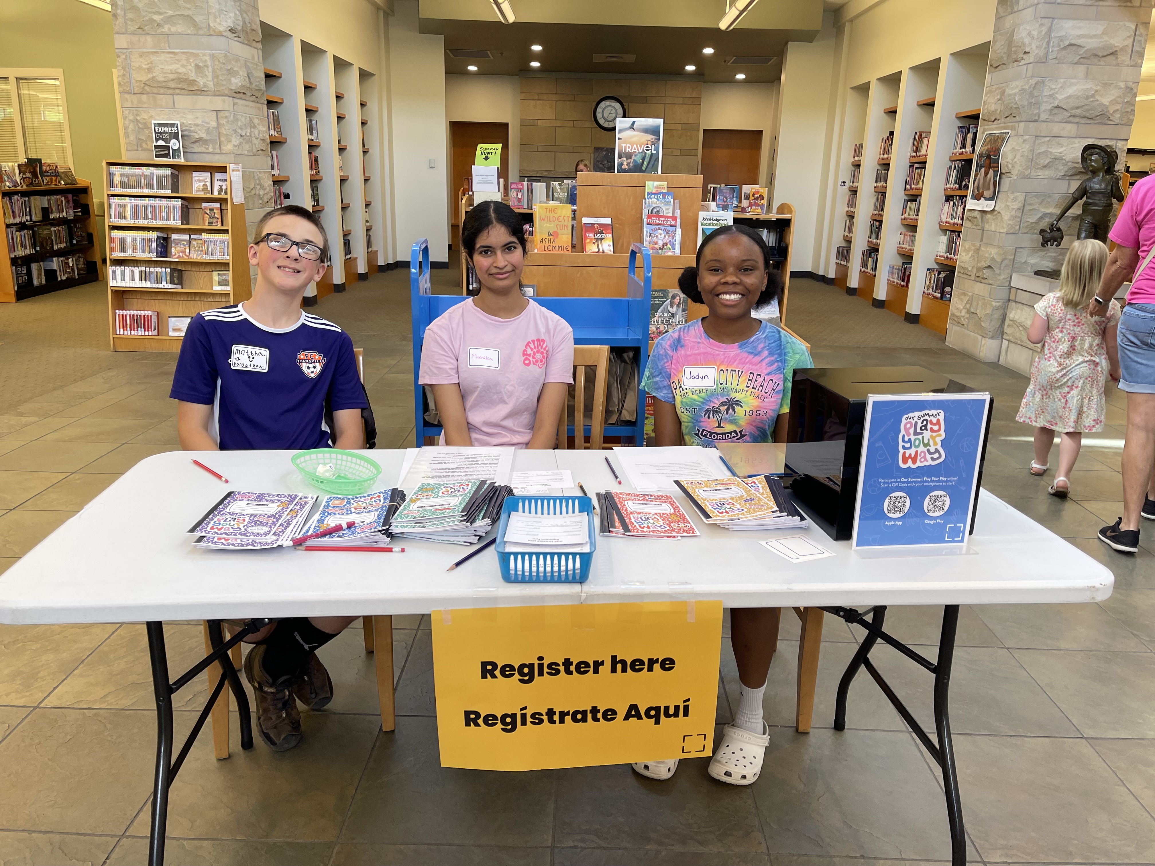 Teen volunteers at library table