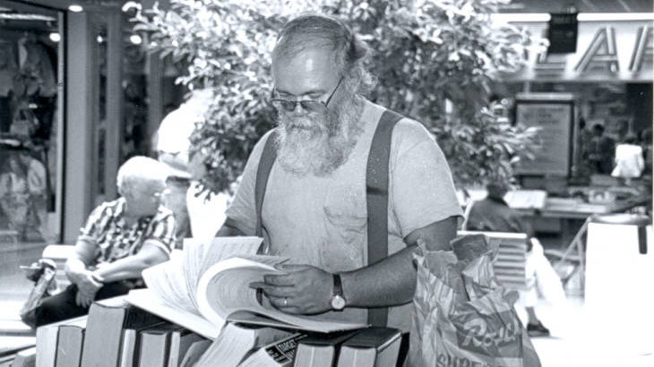 A photograph of a patron shopping at the booksale at Washington Square Mall in 1989.