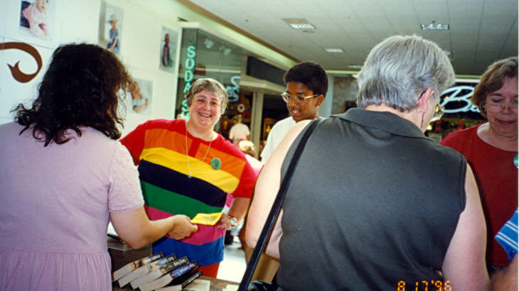 A photograph of the library booksale in 1996 at Washington Square Mall. Pictured is staff member Jan Steinmark.