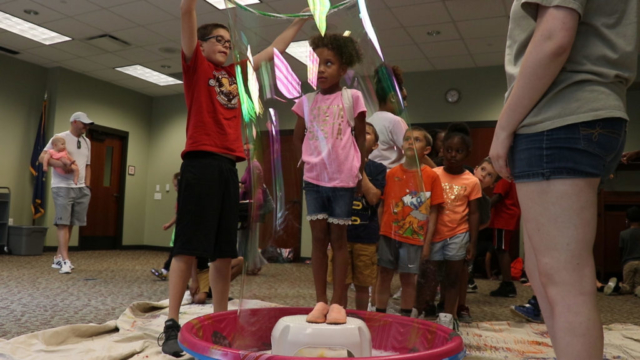 Teen volunteers creates a giant bubble at EVPL North Park's Bubblefest.